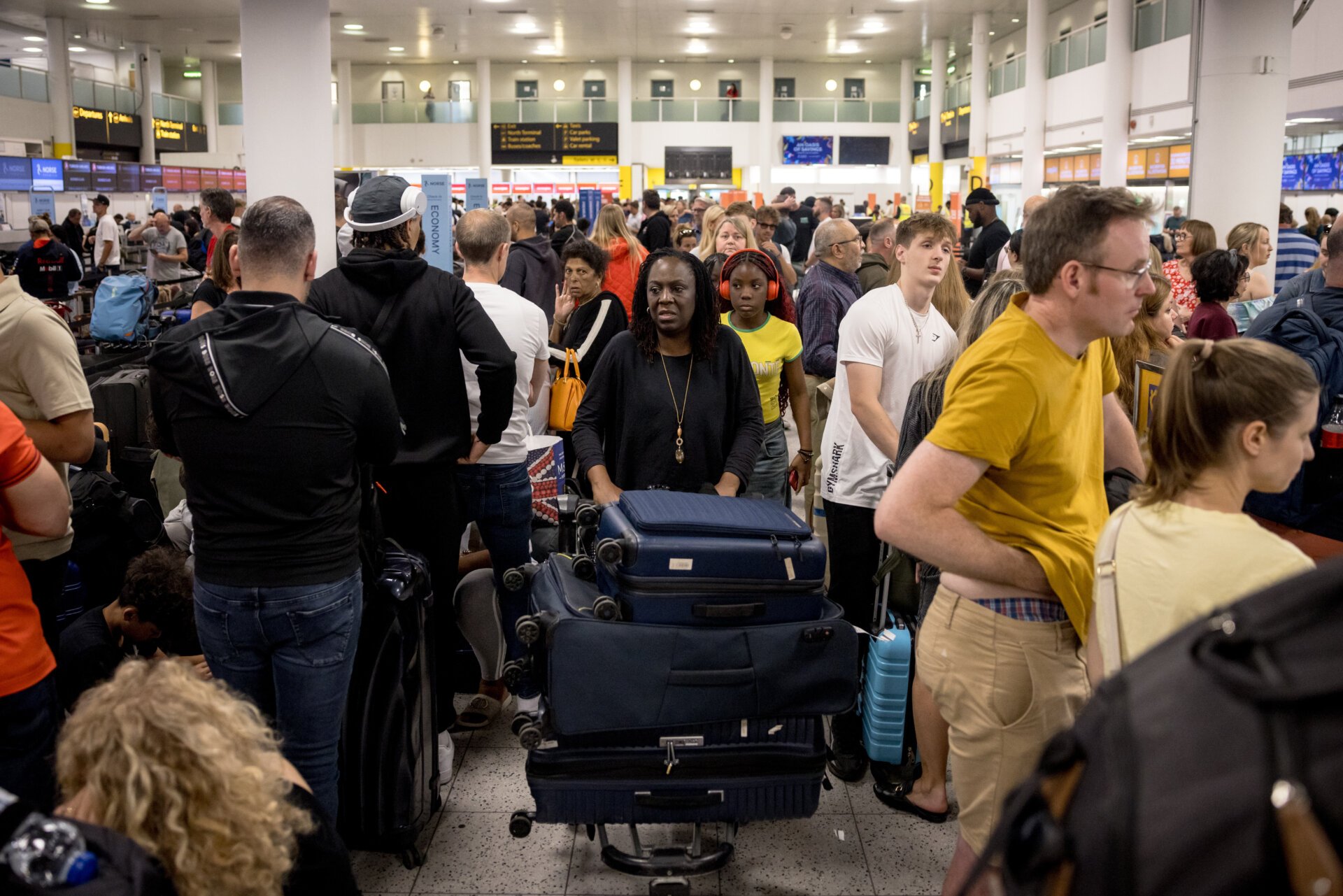 Passengers queue at Gatwick Airport amid a global IT outage on July 19, 2024 in Crawley, United Kingdom. Businesses, travel companies and Microsoft users across the globe were among those affected by a tech outage today.