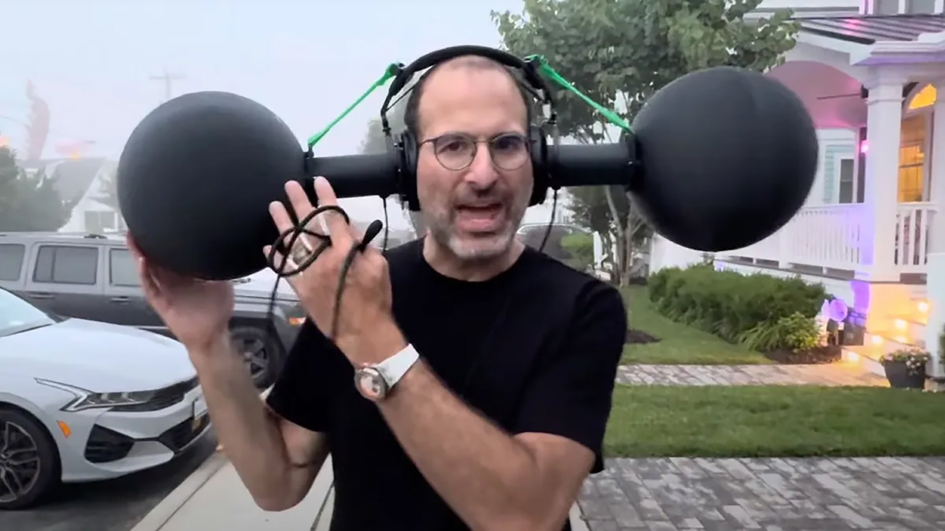 Man wearing headphones with a large black sphere on each end.